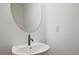 Modern powder room with a vessel sink, sleek faucet, and decorative round mirror, complemented by neutral walls at 699 Sunstone Ln, Lawrenceville, GA 30043