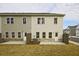 Home exterior featuring light grey siding, windows and a concrete patio at 699 Sunstone Ln, Lawrenceville, GA 30043