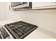 Close-up of a modern stainless steel stovetop with white subway tile backsplash and quartz countertops at 699 Sunstone Ln, Lawrenceville, GA 30043