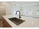 Spacious kitchen island featuring a sink, ample countertop space, and modern fixtures, ideal for meal preparation at 699 Sunstone Ln, Lawrenceville, GA 30043