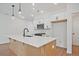 Modern kitchen island featuring quartz countertops, stainless steel appliances, and stylish pendant lighting at 699 Sunstone Ln, Lawrenceville, GA 30043