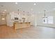 Bright, open-concept kitchen with a central island, white cabinetry, and hardwood floors at 699 Sunstone Ln, Lawrenceville, GA 30043