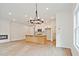 Bright open-concept living room featuring a fireplace and an island kitchen with modern light fixtures at 699 Sunstone Ln, Lawrenceville, GA 30043