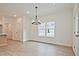 Sun-drenched living room with a large window and wood flooring, showcasing modern lighting and an inviting atmosphere at 699 Sunstone Ln, Lawrenceville, GA 30043