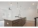 Island kitchen area featuring a large island with sink and stainless steel appliances at 695 Sunstone Ln, Lawrenceville, GA 30043