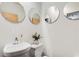 Modern bathroom with white sink, toilet, and three round mirrors at 130 Arizona Ne Ave # 104, Atlanta, GA 30307