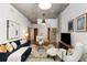 Open-concept living room with concrete ceiling, blue sofa, and a view into the kitchen area at 130 Arizona Ne Ave # 104, Atlanta, GA 30307