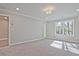 A carpeted bedroom illuminated by natural light through a large window at 693 Sunstone Ln, Lawrenceville, GA 30043