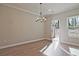 Cozy dining area featuring a modern chandelier, a window view, and hardwood floors at 693 Sunstone Ln, Lawrenceville, GA 30043