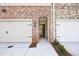 Inviting brick entryway and garage with adjacent manicured landscaping offering curb appeal at 693 Sunstone Ln, Lawrenceville, GA 30043