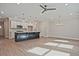 Spacious living area open to kitchen, featuring hardwood floors, a modern island, and chandelier lighting at 693 Sunstone Ln, Lawrenceville, GA 30043