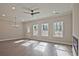 Sunlit living room with modern ceiling fan, light hardwood floors, and three large windows at 693 Sunstone Ln, Lawrenceville, GA 30043