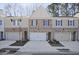 Charming townhome featuring brick and siding, complemented by individual garages and well-manicured landscaping at 691 Sunstone Ln, Lawrenceville, GA 30043