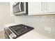 Close-up of the stovetop and microwave with subway tile backsplash and light countertops at 691 Sunstone Ln, Lawrenceville, GA 30043