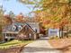 Traditional brick home with a long driveway and a detached garage, surrounded by colorful fall foliage at 775 N Ola N Rd, Mcdonough, GA 30252