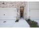Charming brick townhome entrance with attached two-car garage and house number at 689 Sunstone Ln, Lawrenceville, GA 30043