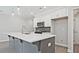Kitchen features an island with sink, grey backsplash, and stainless steel microwave at 689 Sunstone Ln, Lawrenceville, GA 30043