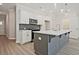 Kitchen with white cabinets, grey island with sink, and stainless steel microwave at 689 Sunstone Ln, Lawrenceville, GA 30043