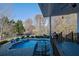 Elevated deck overlooks inground pool with brick patio at 6740 Mountain Lake Ln, Cumming, GA 30028