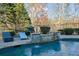 Stone water feature flows into a refreshing blue pool at 6740 Mountain Lake Ln, Cumming, GA 30028