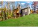 Beautiful home with a large backyard featuring a wood deck and lush green lawn surrounded by fall foliage at 241 Hembree Drive, Canton, GA 30115