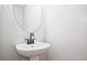Bathroom with a white sink, modern faucet, oval mirror, and neutral wall paint at 687 Sunstone Ln, Lawrenceville, GA 30043
