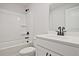 Clean, all-white bathroom features a tub and shower combo, a modern vanity, and sleek, black fixtures at 687 Sunstone Ln, Lawrenceville, GA 30043