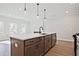 Kitchen island featuring a modern faucet, stainless steel sink, and quartz countertop at 687 Sunstone Ln, Lawrenceville, GA 30043