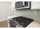 Close up of the kitchen gas range with modern stainless steel appliances and white cabinets at 687 Sunstone Ln, Lawrenceville, GA 30043