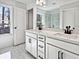 A bright bathroom features a double vanity, a large mirror, and elegant tile flooring at 685 Sunstone Ln, Lawrenceville, GA 30043