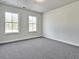 This bedroom features neutral carpet, white walls, and two bright, sunny windows at 685 Sunstone Ln, Lawrenceville, GA 30043
