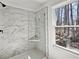 Modern glass shower with marble-style tile and a built-in corner shelf at 685 Sunstone Ln, Lawrenceville, GA 30043
