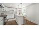 Modern white kitchen with island, stainless steel appliances, and hardwood floors at 599 Quillian Ave., Decatur, GA 30032