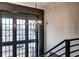 Stylish entryway with multi-pane windows, dark trim, a modern chandelier, and stairs leading to the upper level at 00 Ryker Rd, Cumming, GA 30041