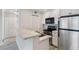 Open kitchen featuring modern appliances, white cabinets, and a breakfast bar at 201 Granville Ct, Atlanta, GA 30328