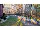 Landscaped backyard featuring a black fence, stone accents, lush lawn, and mature trees for privacy at 271 Brooks Rackley Rd, Dallas, GA 30157