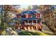 Stunning three-story red brick home with a balcony and a beautifully landscaped yard surrounded by autumn trees at 271 Brooks Rackley Rd, Dallas, GA 30157