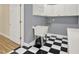 A laundry room with black and white checkered floors, white cabinets, and a utility sink at 271 Brooks Rackley Rd, Dallas, GA 30157