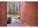 Side yard patio, brick wall, landscaped lawn, with fenced backyard and trees at 271 Brooks Rackley Rd, Dallas, GA 30157