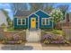 Charming blue bungalow featuring a bright yellow front door and a quaint white picket fence at 1196 Oleander Nw St, Atlanta, GA 30314