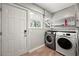 Bright laundry room with a modern washer and dryer, shelving, and a window at 1196 Oleander Nw St, Atlanta, GA 30314