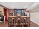 Basement bar with stone and wood finishes, seating, and wine storage at 6220 Vickery Creek Rd, Cumming, GA 30040