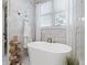 Bathroom with freestanding soaking tub and marble tile at 6220 Vickery Creek Rd, Cumming, GA 30040