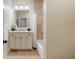 Bathroom with a white vanity, tub shower combo and beige tile floors at 6715 Berkley Rd, Cumming, GA 30040