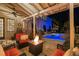 Night view of a covered patio with fire pit and comfortable seating at 6715 Berkley Rd, Cumming, GA 30040