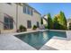 Modern rectangular pool with light-colored stone patio and lush greenery at 6715 Berkley Rd, Cumming, GA 30040