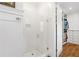 Bright bathroom with a white tiled shower featuring a glass door and a view into the walk-in closet at 6830 Vickery Creek Rd, Cumming, GA 30040