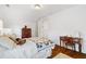 Bright bedroom featuring hardwood floors, and a cozy bed with colorful quilt and a vintage desk with mirror at 6830 Vickery Creek Rd, Cumming, GA 30040