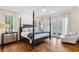 Main bedroom with four-poster bed, hardwood floors, and French doors at 6830 Vickery Creek Rd, Cumming, GA 30040