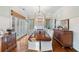 Bright dining room with a long table, white chairs, decorative cabinets, and windows with natural light at 6830 Vickery Creek Rd, Cumming, GA 30040